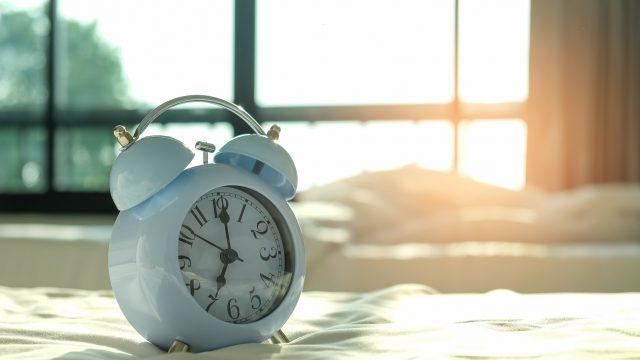 An alarm clock on silk bedding